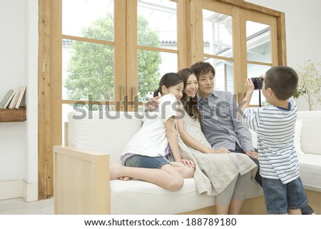 boy taking photograph of parents and elder sister