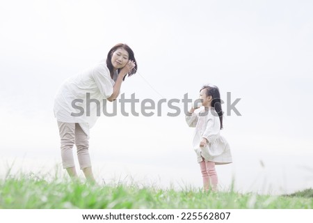 Mother and child playing with a string telephone