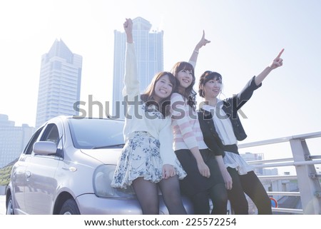 Woman with the friend in front of the car