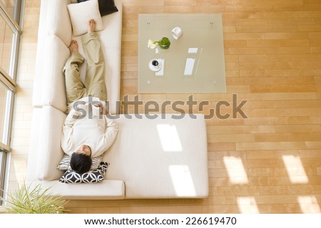 Man lying down on sofa in the living room