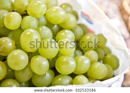 Bright, green grapes under indoor lighting.