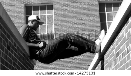 Attractive young African American male playing posing in a t-shirt, jeans, baseball cap.