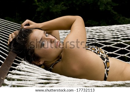 Sexy brunette posing in patterned bikini while laying outside on a sunny day