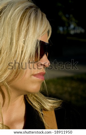 Shot of the side of a blonde womans face wearing sunglasses