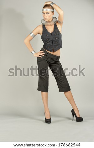 A young female model experimenting with fashionable elements in a studio setting.
