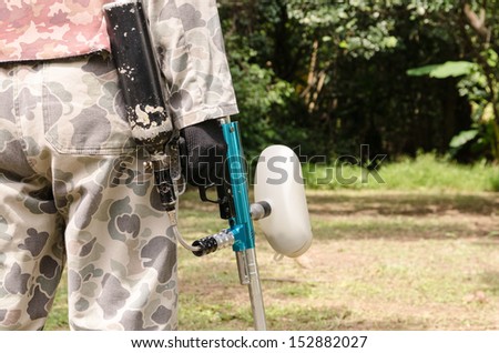 paintball sport player in protective uniform and gun