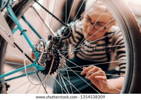 Similar – Image, Stock Photo Woman fixing bike in workshop