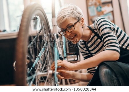 Image, Stock Photo Woman fixing bike in workshop