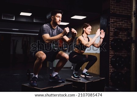 Similar – Image, Stock Photo Focused sportswoman doing squats with elastic band in apartment