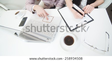 Office table top view, office workers with lap top, notes, coffee.