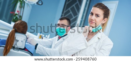 Portrait of beautiful female dentist at busy dentist office.
