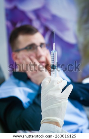 Vaccine at dentist office, shallow depth of field, scary patient in background.