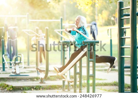 Healthy Senior  Woman doing Exercises for Legs Outdoors in the Bright Autumn Evening