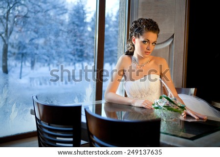 Beautiful Bride Sitting near the window in the Wonderful Winter Evening