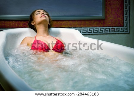 Healthy Spa: Young Beautiful Relaxing Woman Lying in the Bath with Hydro Massage.