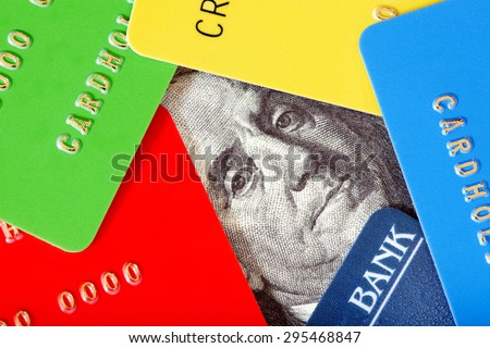 Close-up of Five Colorful Credit Cards (Red, Yellow,Green and Blue) around the Dollar Note