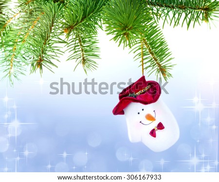 Mitten Snowman on the Christmas Tree at the Defocused Lights Background