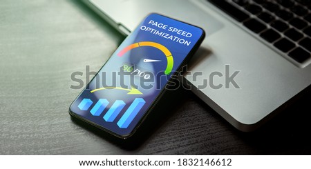 Mobile Page Speed Optimization concept. Website Page Speed Loading Time image for internet SEO. Mobile phone lying on a wooden table next to the laptop and on the screen accelerometer with high values