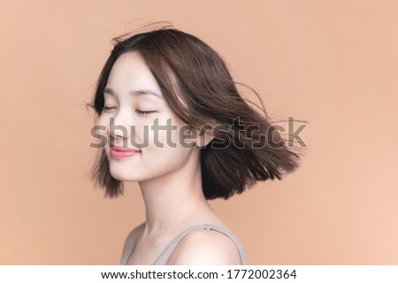 Beauty concept of an asian girl. Hair care. Skin care. Cosmetics. Yellow background.