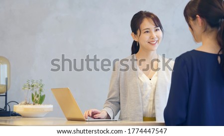 Young asian receptionist talking with customers. Hotel worker. Store clerk.