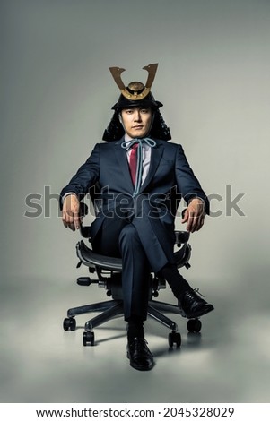 Japanese businessman wearing a samurai's helmet who sits on office chair. Photo stock © 