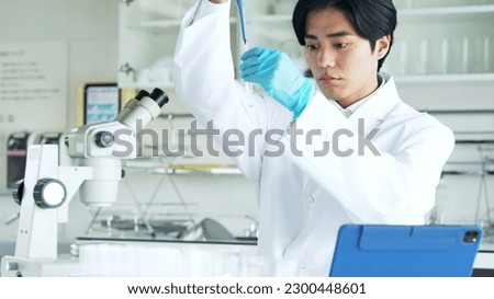 Similar – Image, Stock Photo Serious chemist examining liquid in flask in lab