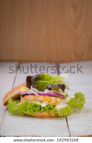 Fish burger. Salmon burger with lettuce and cream of tartar