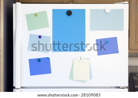 White refrigerator door with colorful notes for lists and messages, posted with magnets.