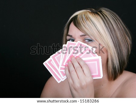 a young woman holding cards hiding her poker face