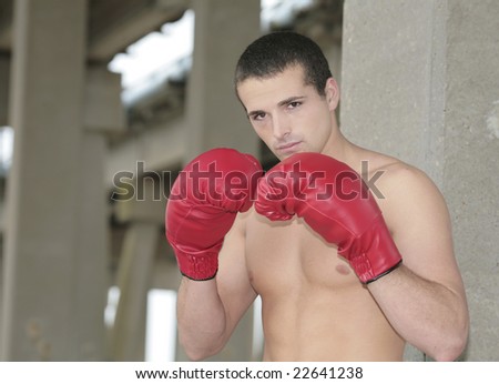 a young male boxer with red gloves outdoors