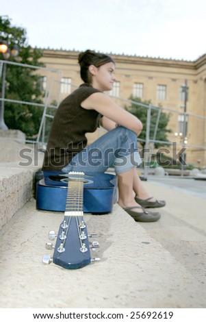 one young brunette woman sitting near a blue guitar