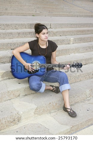 one young brunette woman playing a blue guitar