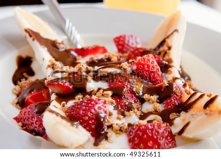 one healthy plate of banana split with yogurt, strawberries and low fat hot fudge topping