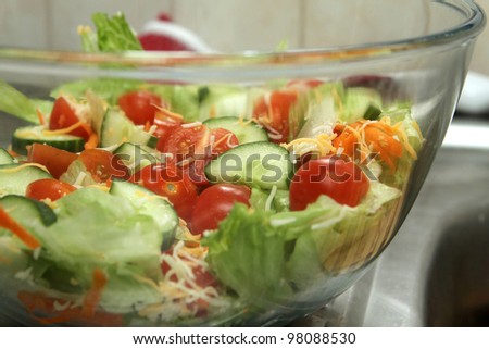 closeup looking through a glass bowl at a garden salad in a home kitchen
