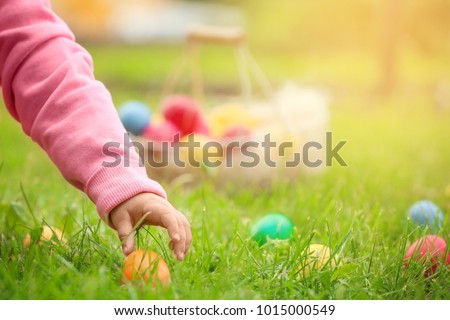 Little girl gathering colorful egg in park. Easter hunt concept Сток-фото © 