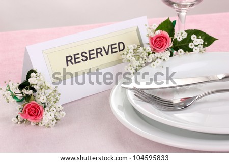 Table setting with reserved card in restaurant