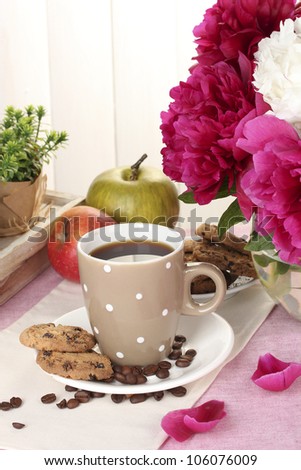 cup of coffee, cookies, apples and flowers on table in cafe
