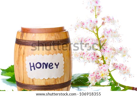 a barrel of honey and chestnut flowers on white background close-up