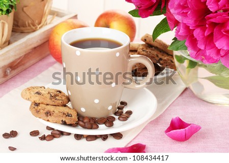 cup of coffee, cookies, apples and flowers on table in cafe