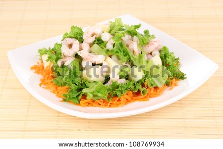 Delicious marinated shrimp in plate on bamboo mat