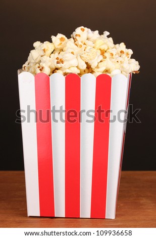 classic box of popcorn on wooden table on brown background