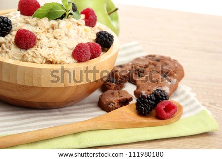 tasty oatmeal with berries, on wooden table