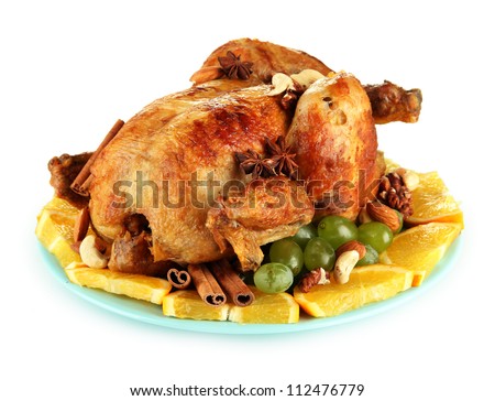 whole roasted chicken with grapes, oranges and spices on blue plate isolated on white