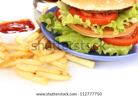 Big and tasty hamburger on plate with cola and fried potatoes close-up