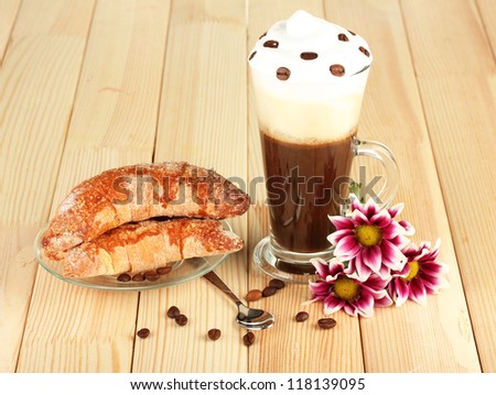 glass of fresh coffee cocktail and saucer with bagels on wooden background