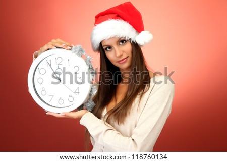 beautiful young woman with clock, on red background