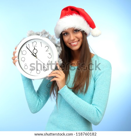 beautiful young woman with clock, on blue background