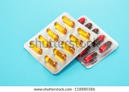 Capsules packed in blisters, on blue background