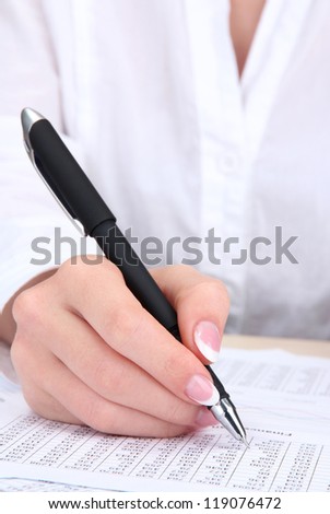 Closeup of businesswoman hand, writing on paper