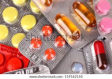 Capsules and pills packed in blisters close-up background